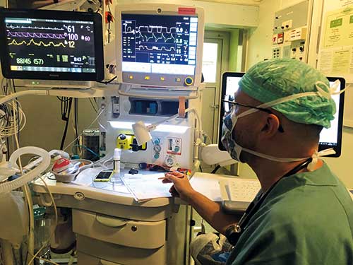 medical professional in scrubs looking at monitors medical professional in scrubs looking at monitors